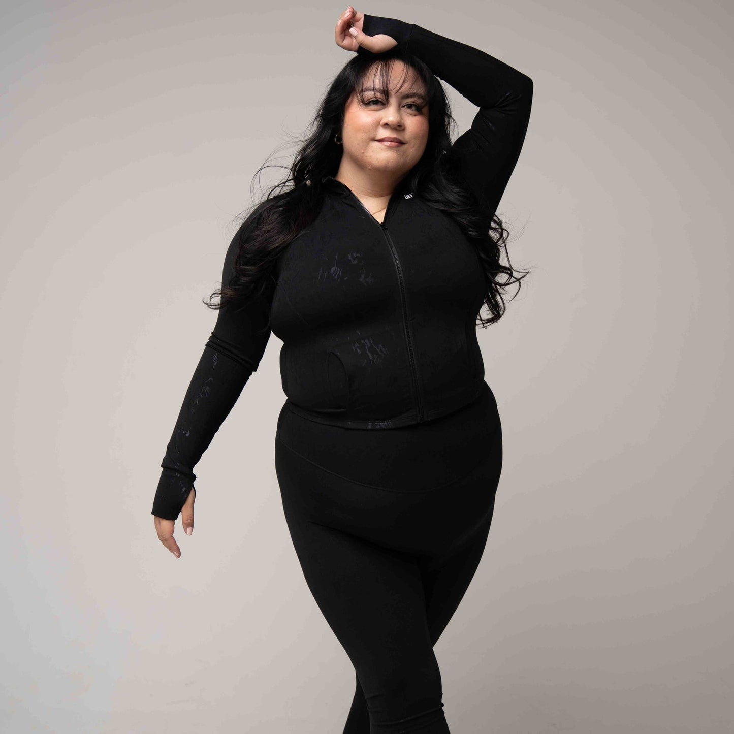 Woman wearing a black outfit against a plain background