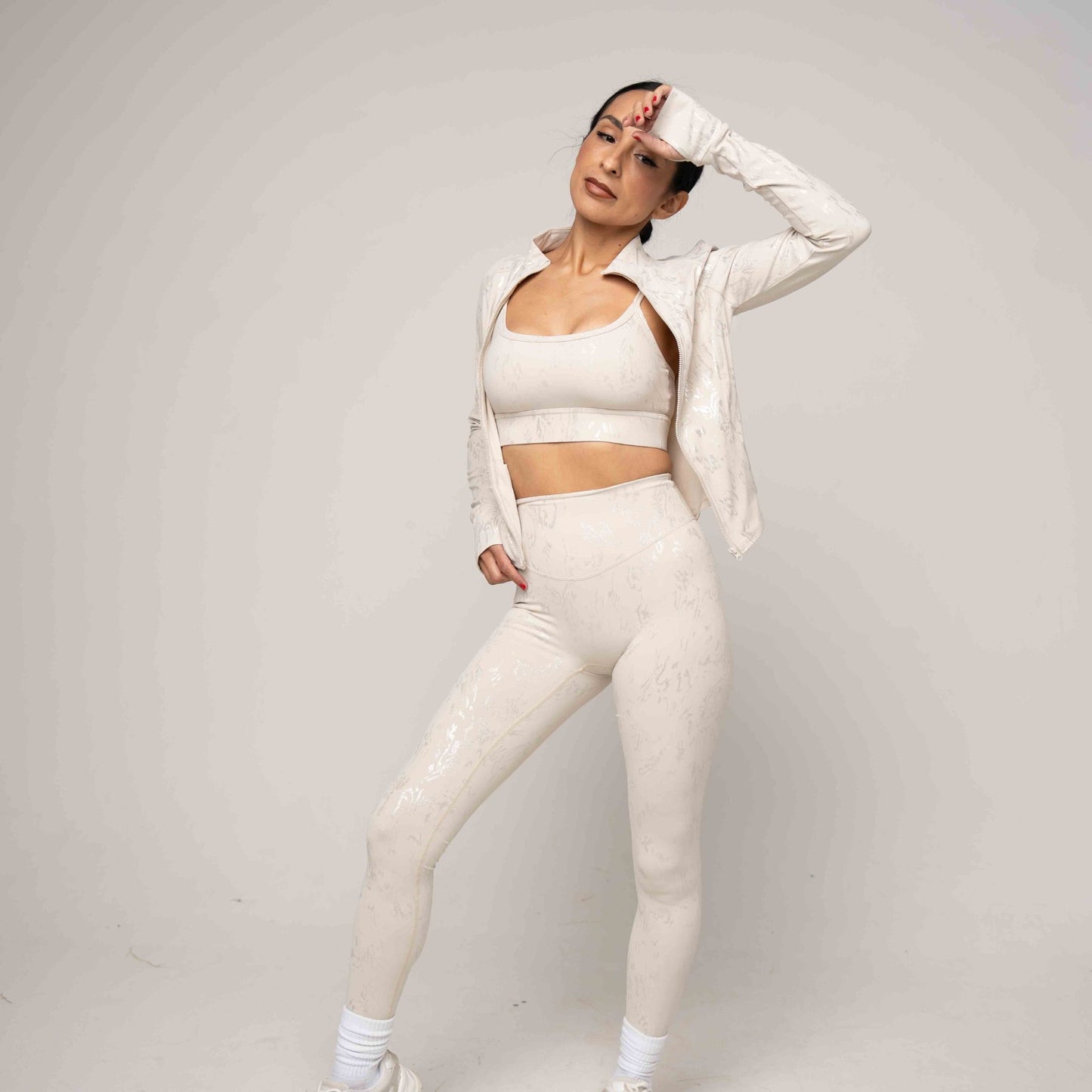 Person wearing a light beige athletic outfit on a plain background