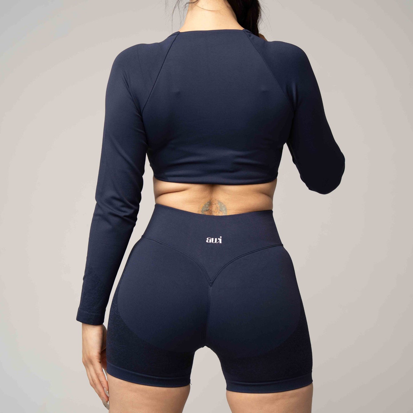 Person wearing a navy blue athletic outfit with 'ari' branding on a plain background