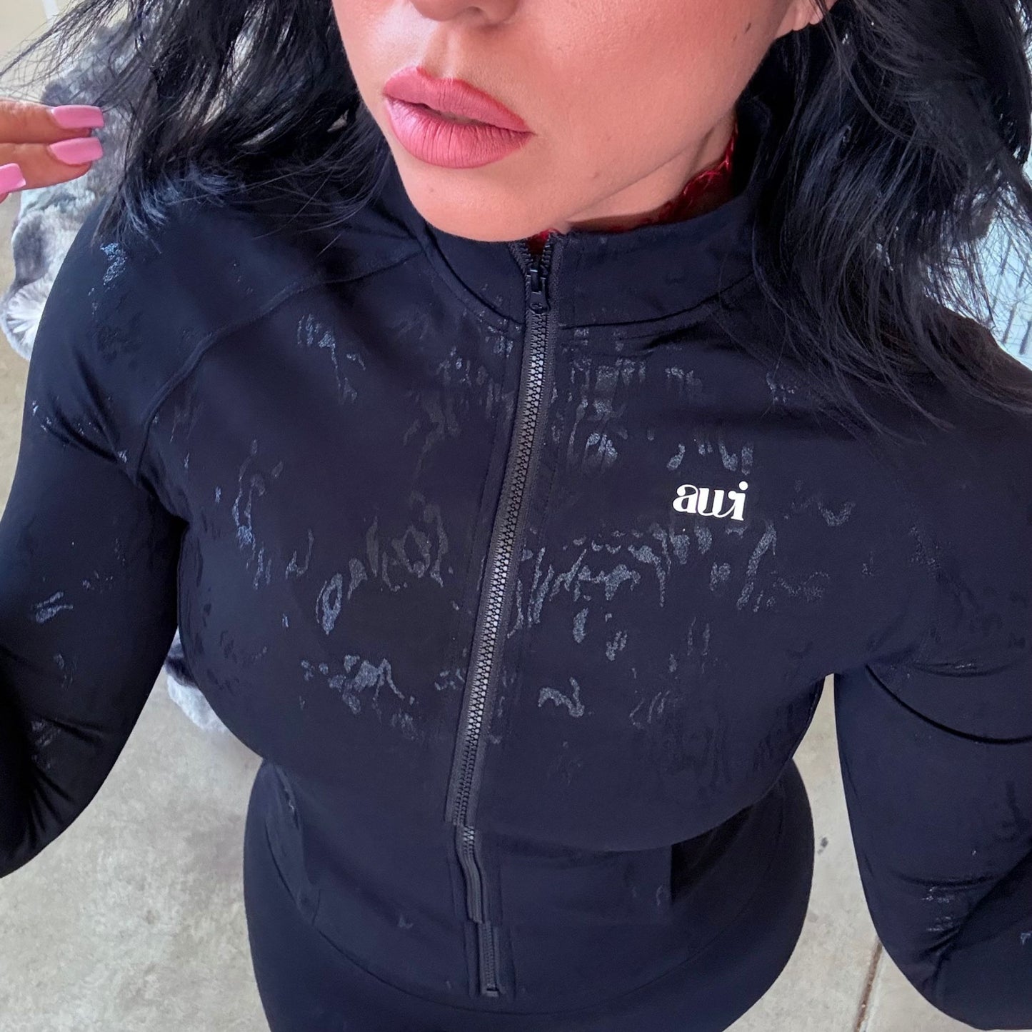 Close-up of the Avvi sculpting zip jacket featuring subtle textured print and sleek finish.