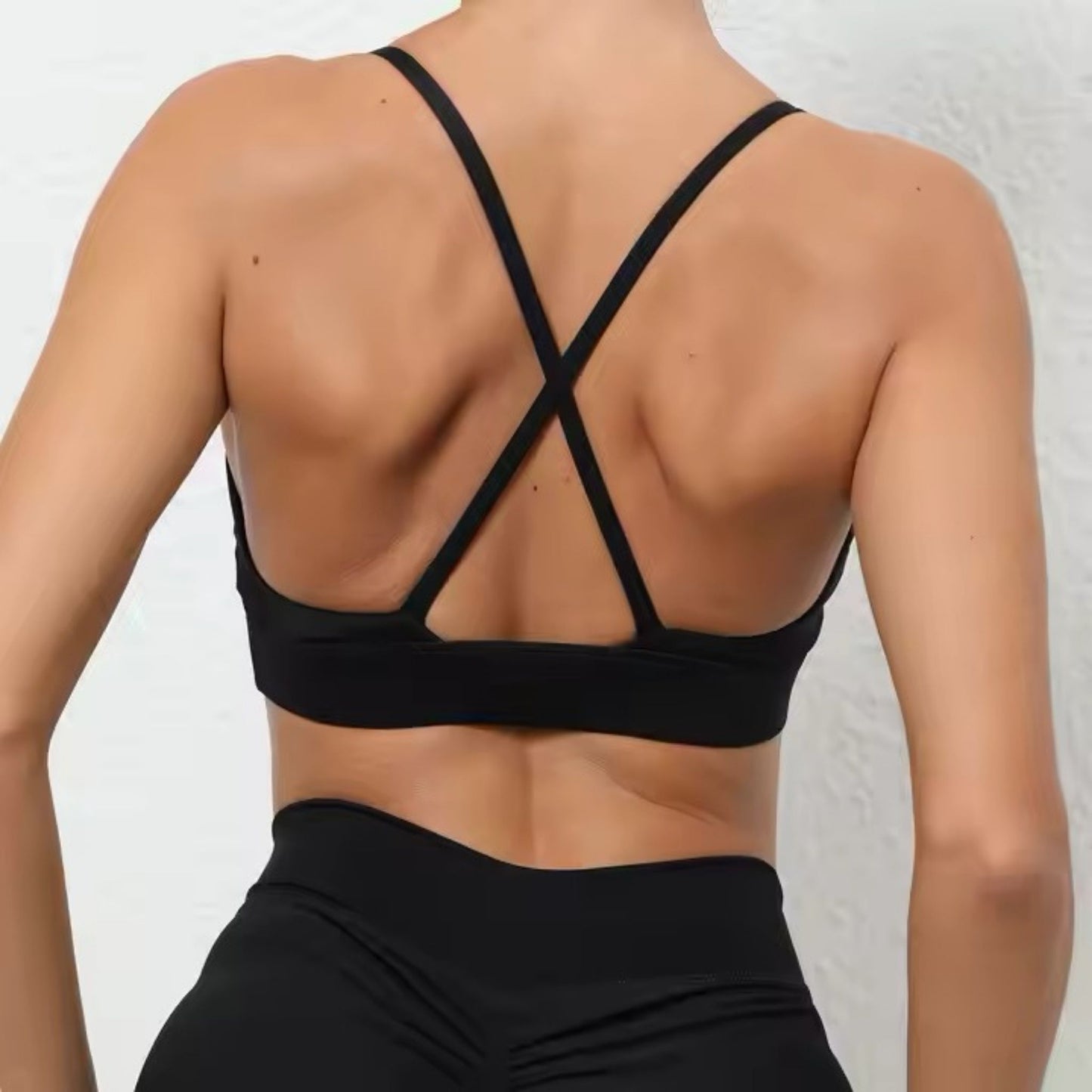 Plunge sports bra by avvi in black, deep V neckline with crossback straps, minimal sculpted activewear top.