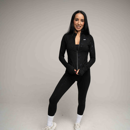 Woman wearing a black athletic outfit on a gray background