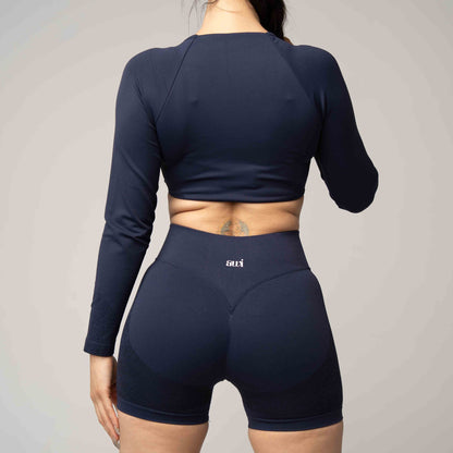 Person wearing a navy blue athletic outfit with 'ari' branding on a plain background